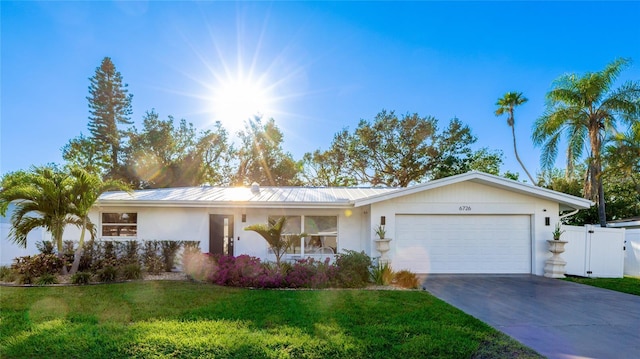 single story home featuring a front lawn and a garage