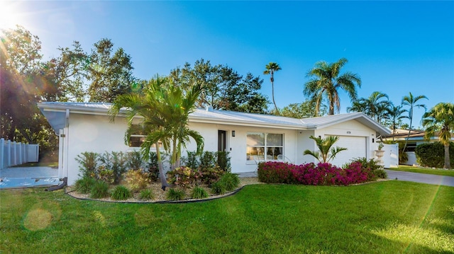 single story home featuring a garage and a front lawn