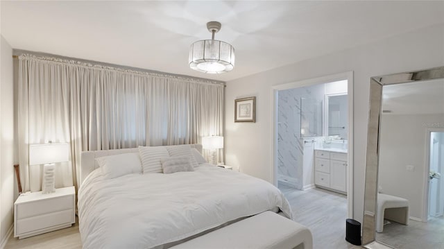 bedroom featuring connected bathroom and light hardwood / wood-style floors