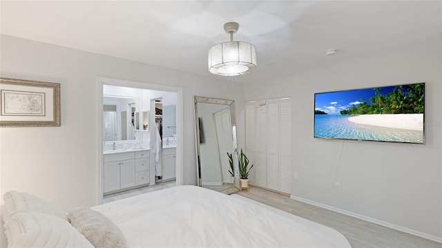 bedroom featuring light hardwood / wood-style floors and ensuite bathroom