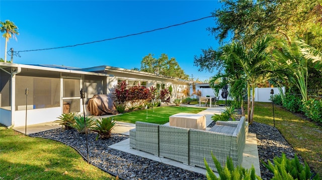 rear view of property featuring outdoor lounge area, a sunroom, and a patio