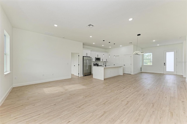 unfurnished living room featuring light wood-type flooring and sink