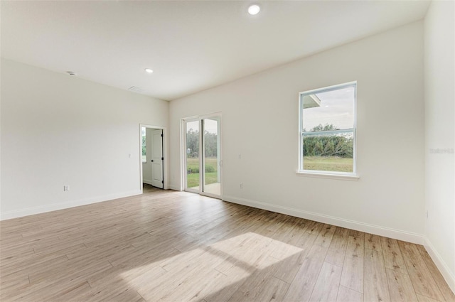 spare room with light wood-type flooring and a wealth of natural light