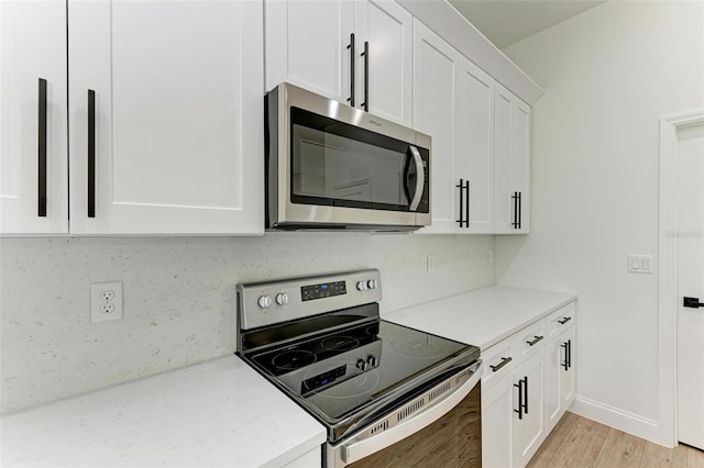 kitchen featuring decorative backsplash, light wood-type flooring, white cabinetry, and stainless steel appliances