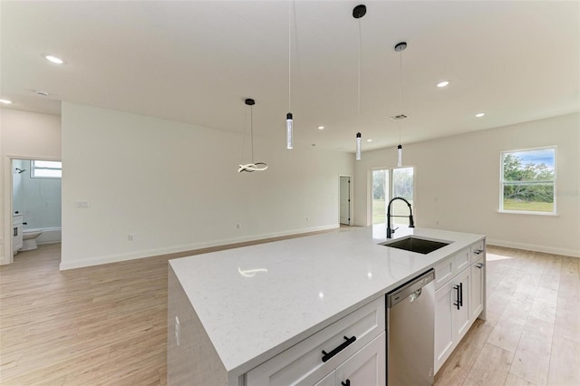 kitchen with sink, stainless steel dishwasher, decorative light fixtures, a center island with sink, and white cabinets