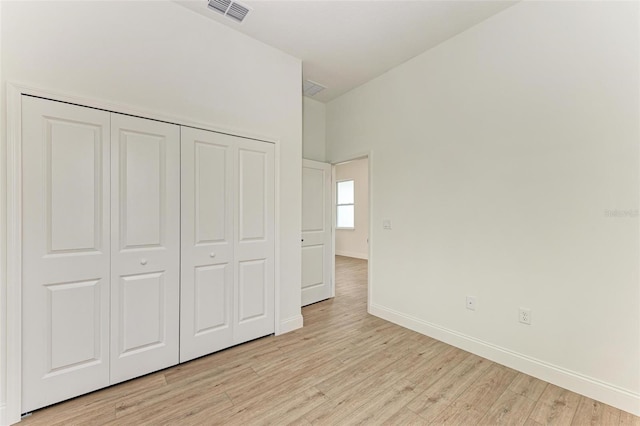 unfurnished bedroom with light hardwood / wood-style floors and a closet