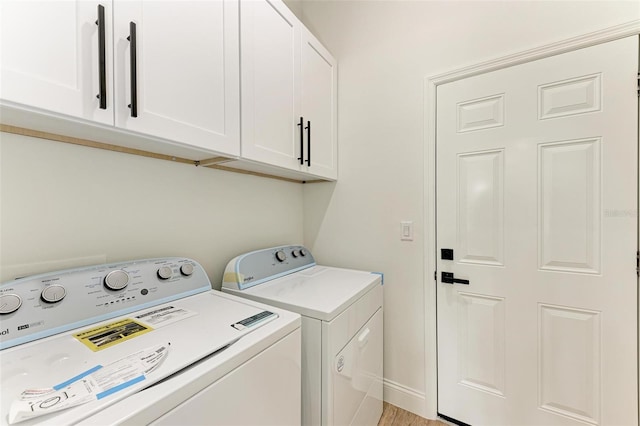 clothes washing area featuring cabinets and washing machine and dryer