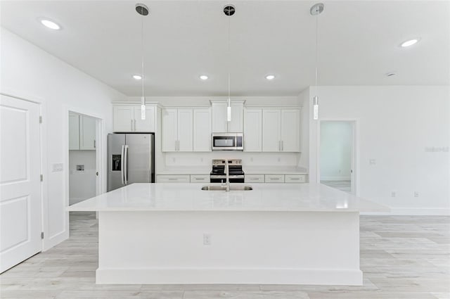 kitchen featuring white cabinets, pendant lighting, stainless steel appliances, and a spacious island