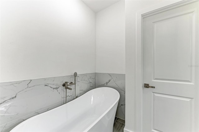 bathroom with a bath and tile walls