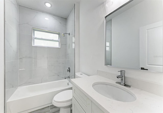 full bathroom featuring vanity, toilet, and tiled shower / bath