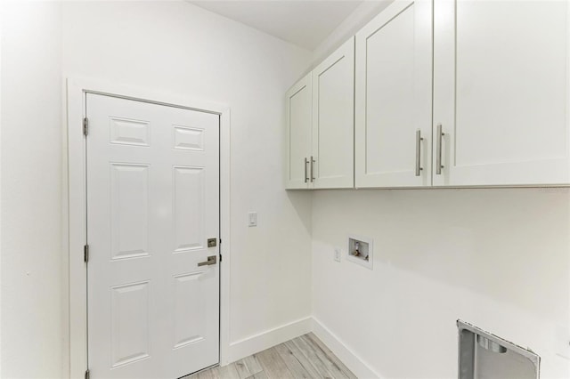 washroom with cabinets, light wood-type flooring, and hookup for a washing machine