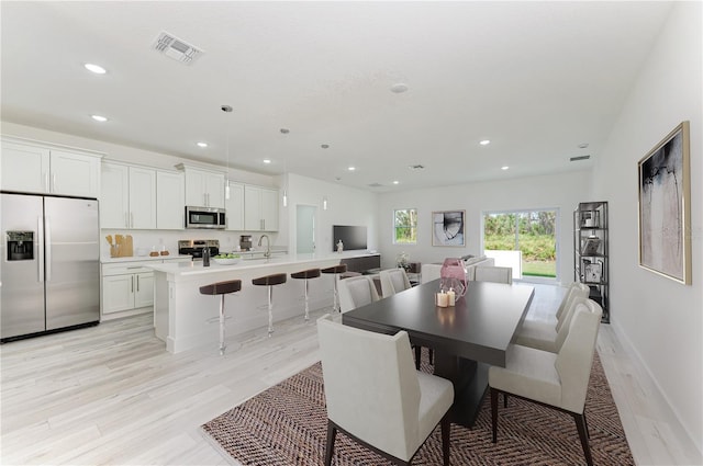 dining area featuring sink and light wood-type flooring