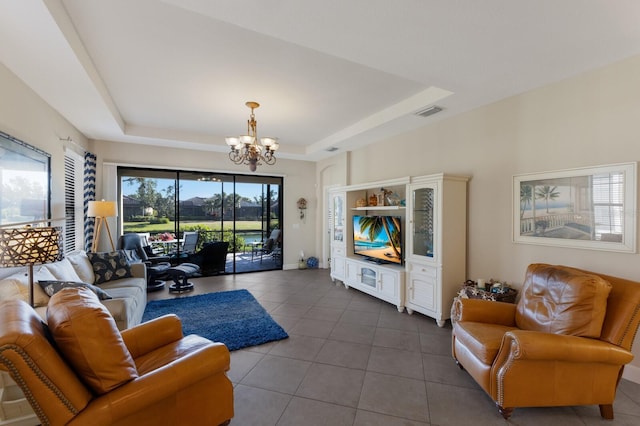 tiled living room with a tray ceiling and a notable chandelier