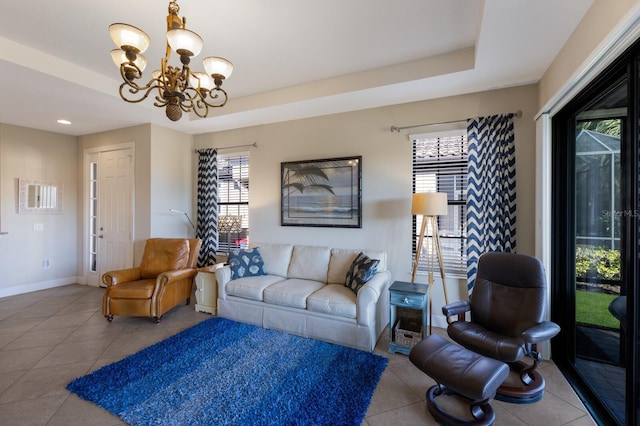 living room featuring a raised ceiling, tile patterned flooring, and a chandelier