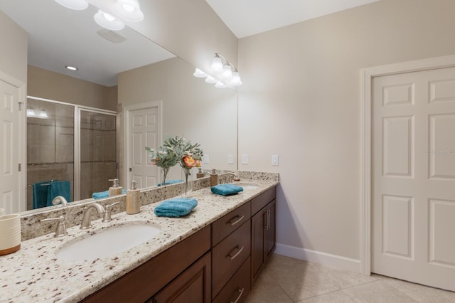 bathroom with tile patterned flooring, a shower with shower door, and vanity