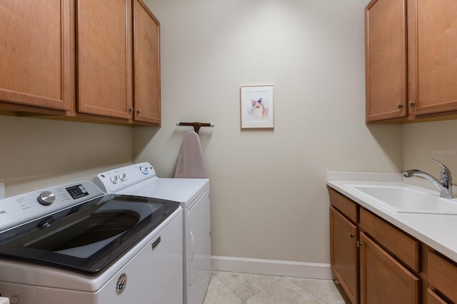 laundry area featuring light tile patterned flooring, sink, washing machine and clothes dryer, and cabinets