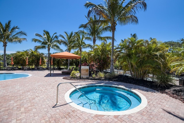 view of pool featuring a patio area, a community hot tub, and a gazebo