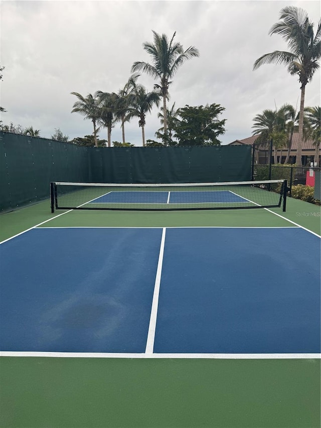 view of tennis court featuring basketball hoop