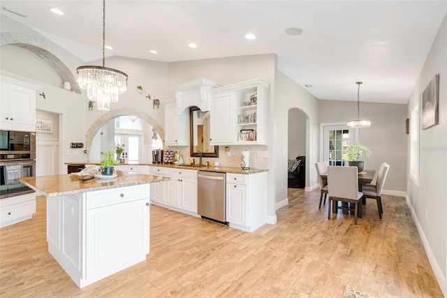 kitchen with white cabinets, decorative light fixtures, a center island, and stainless steel appliances