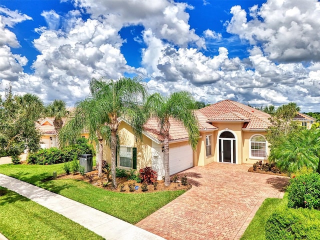 mediterranean / spanish home with a front lawn and a garage