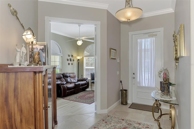 tiled entrance foyer with ceiling fan and ornamental molding