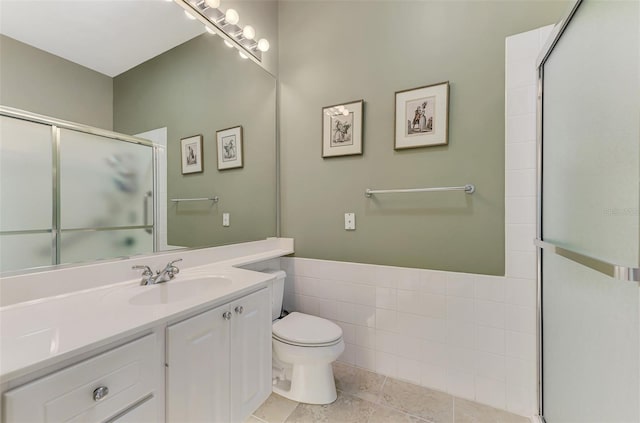 bathroom with vanity, toilet, and a shower with door