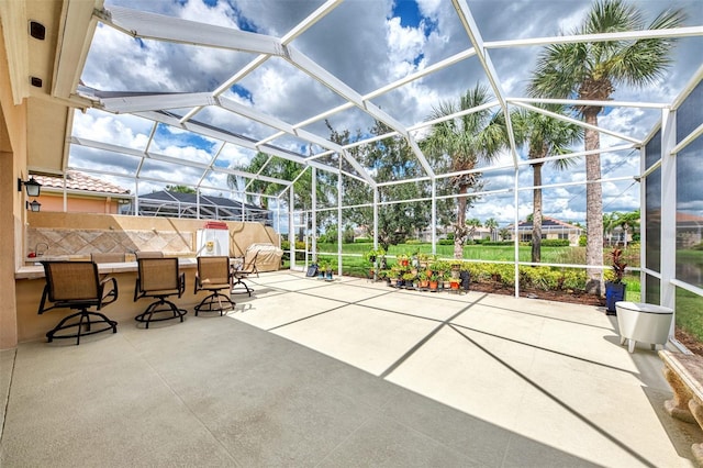 view of patio with exterior bar and glass enclosure