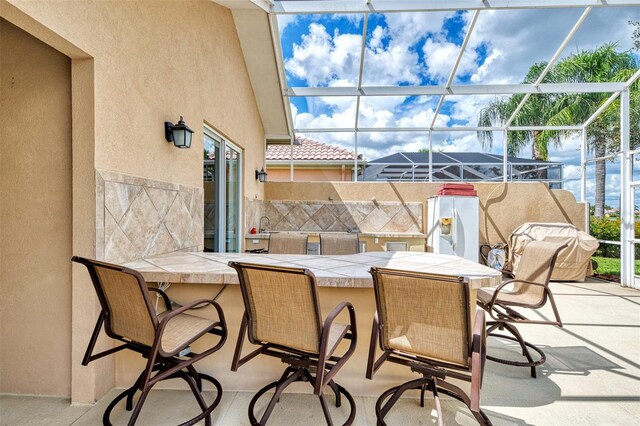 view of patio / terrace with glass enclosure and exterior bar