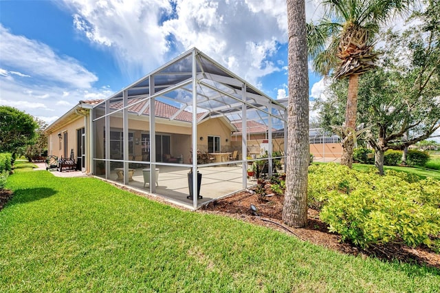 rear view of house with a lanai, a patio area, and a yard