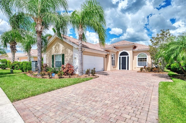 mediterranean / spanish-style home with a garage and a front yard