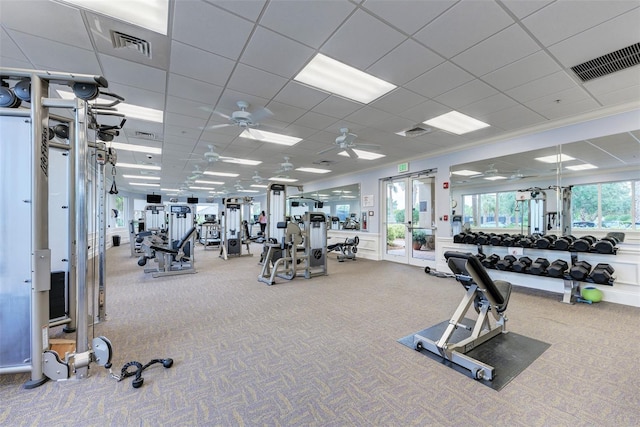 exercise room with a paneled ceiling, ceiling fan, carpet floors, and ornamental molding