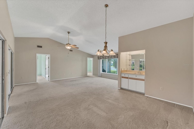 unfurnished living room featuring light carpet, a textured ceiling, ceiling fan with notable chandelier, and vaulted ceiling