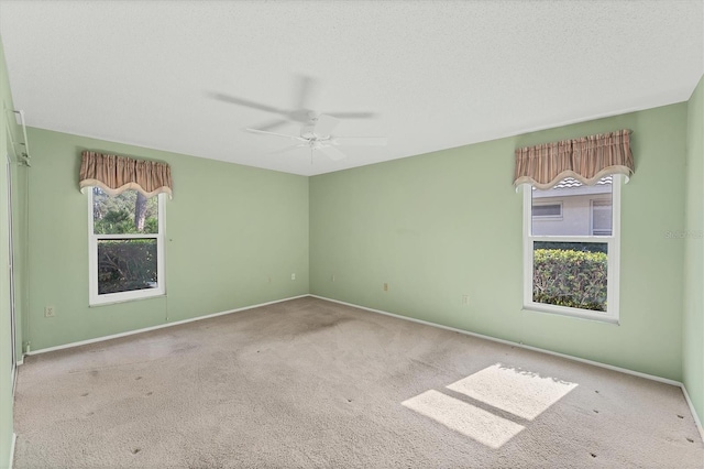 carpeted spare room with ceiling fan and a textured ceiling