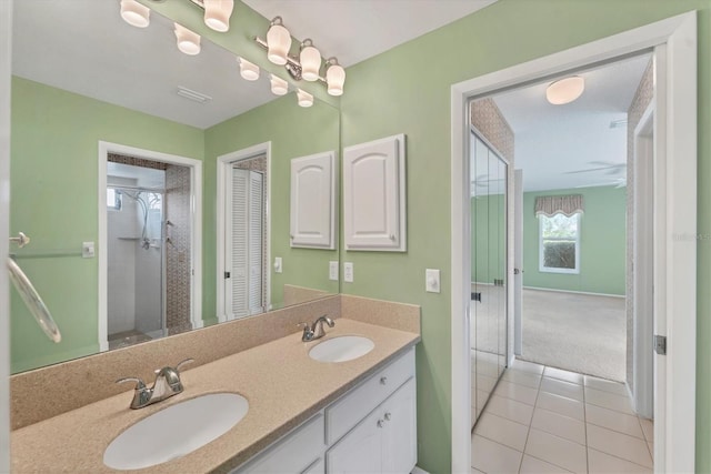 bathroom with a shower, tile patterned flooring, and vanity