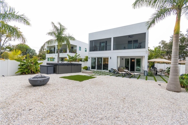 back of property featuring a hot tub, a fire pit, ceiling fan, and a patio area