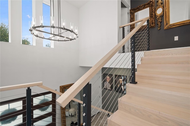 staircase with hardwood / wood-style flooring and a notable chandelier