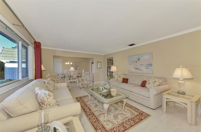 living room featuring crown molding, light hardwood / wood-style flooring, and a chandelier