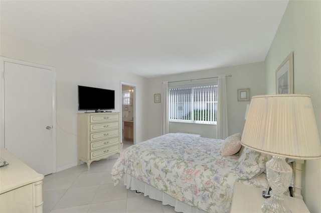 bedroom featuring ensuite bathroom and light tile patterned floors