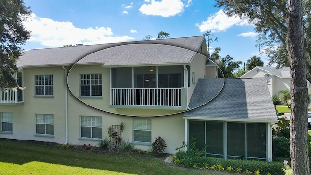 rear view of property with a sunroom and a lawn