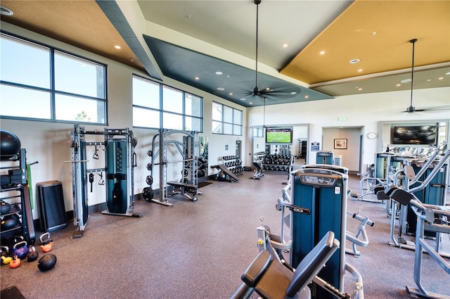 gym with ceiling fan and a high ceiling