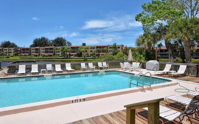 view of pool with a patio area and a water view