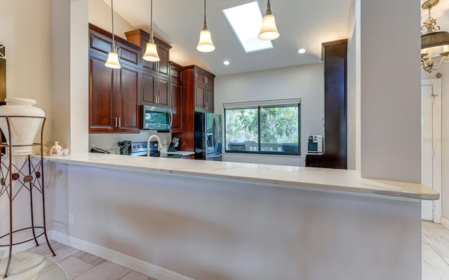 kitchen with kitchen peninsula, light stone countertops, a skylight, stainless steel appliances, and hanging light fixtures