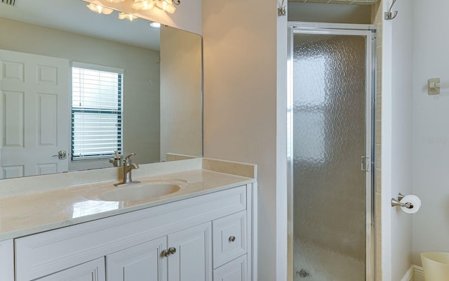 bathroom featuring vanity and a shower with door