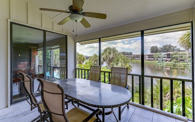 sunroom / solarium featuring a water view, ceiling fan, and lofted ceiling