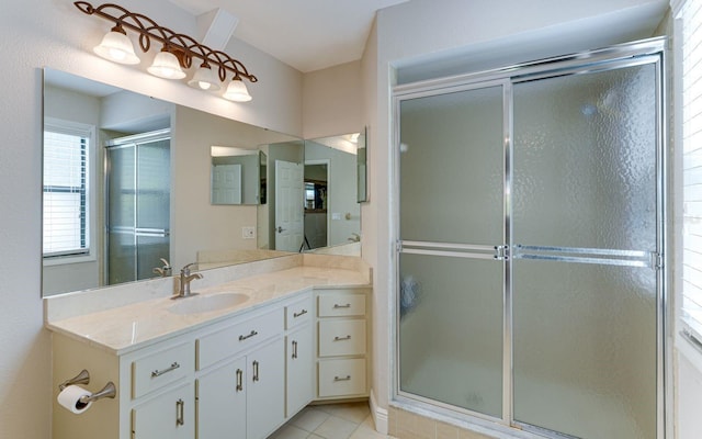 bathroom with tile patterned flooring, vanity, and walk in shower