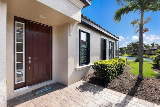 view of exterior entry with a water view