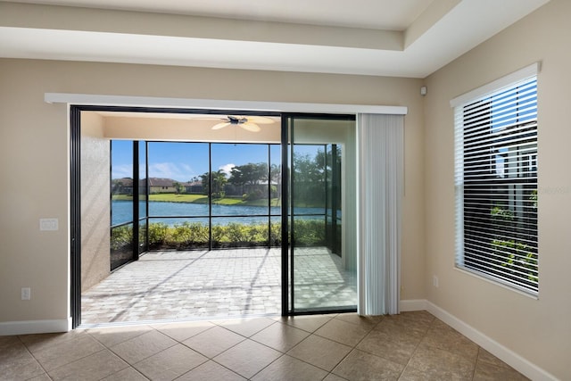 entryway featuring light tile patterned flooring, ceiling fan, and a water view