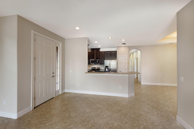 kitchen with kitchen peninsula, stainless steel appliances, and dark brown cabinetry