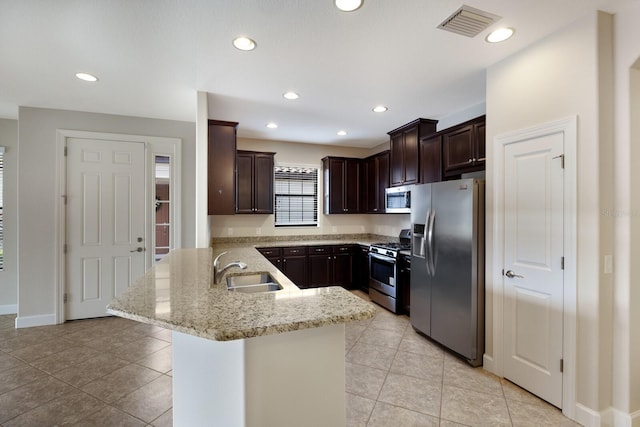 kitchen featuring stainless steel appliances, kitchen peninsula, light tile patterned floors, light stone counters, and sink