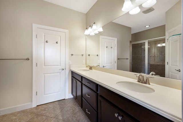 bathroom featuring a shower with door, tile patterned floors, and vanity